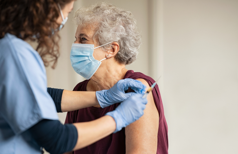 A practice nurse administering COVID-19 vaccine AstraZeneca to a senior patient in COVID-19 vaccine GP clinic in Melbourne