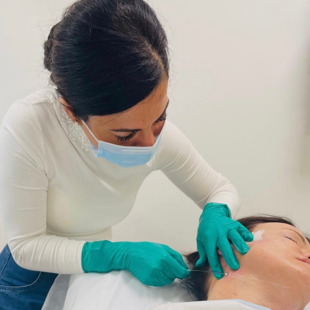 A cosmetic doctor administering a thread facelift or lunchtime facelift to a patient's neck in the cosmetic clinic in Mornington
